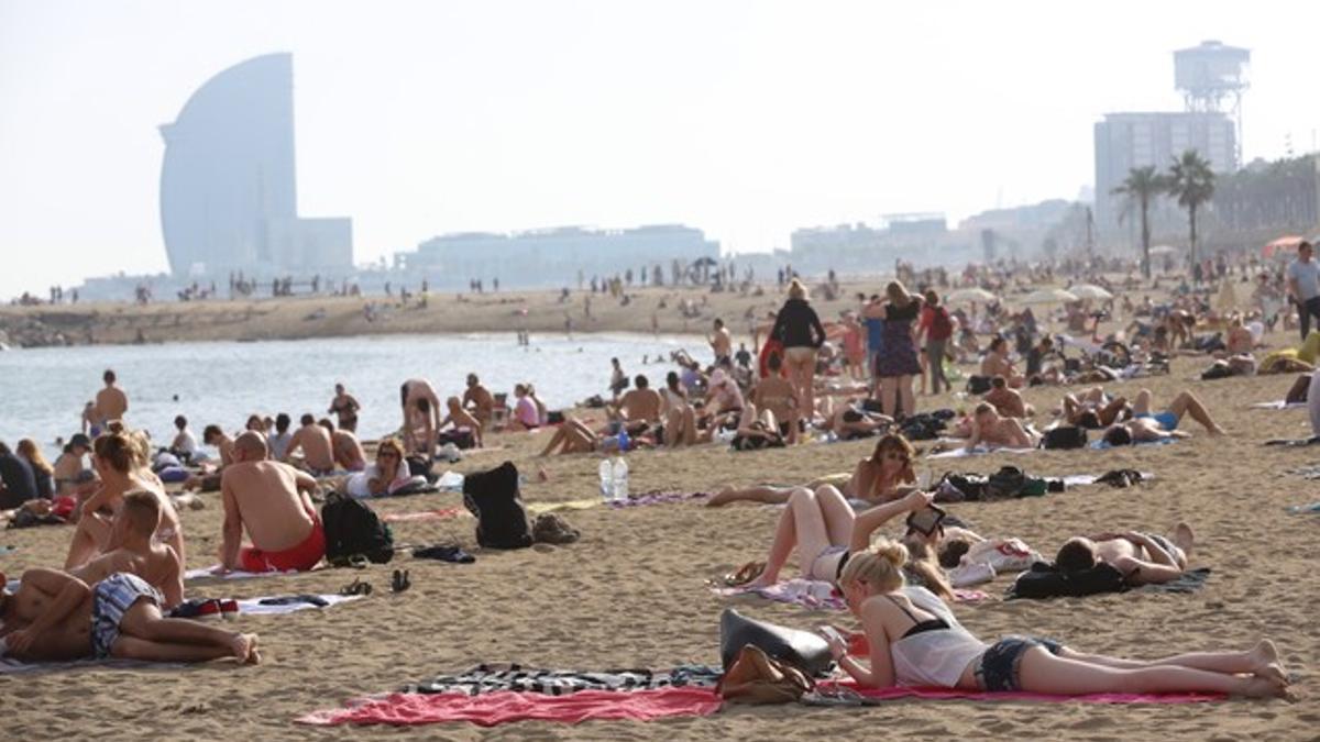 Gente tomando el sol y bañándose en la playa del Somorrostro de Barcelona, el pasado día 19.