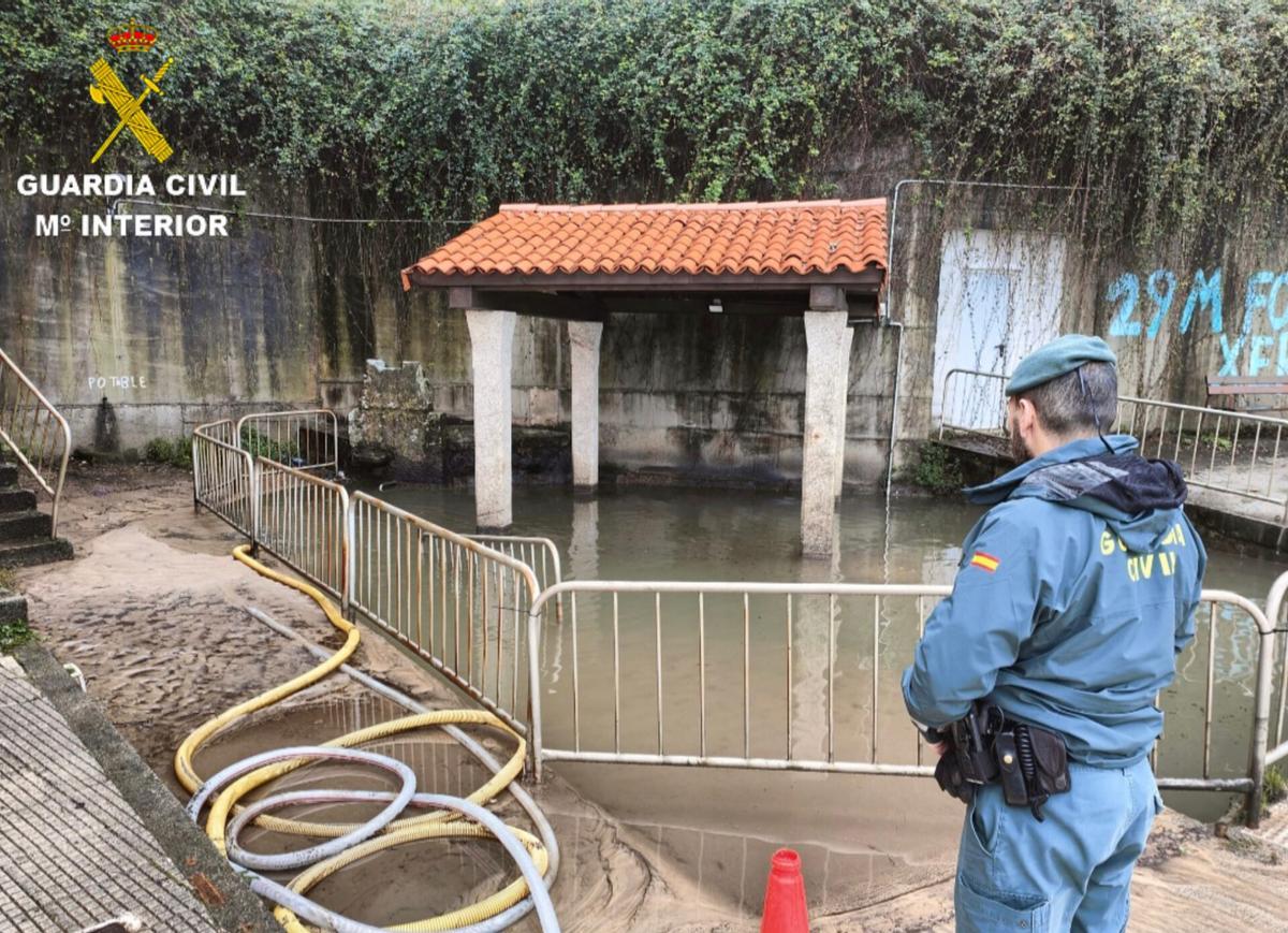 Un agente del Seprona en la inspección del lavadero inundado de A Regueira.