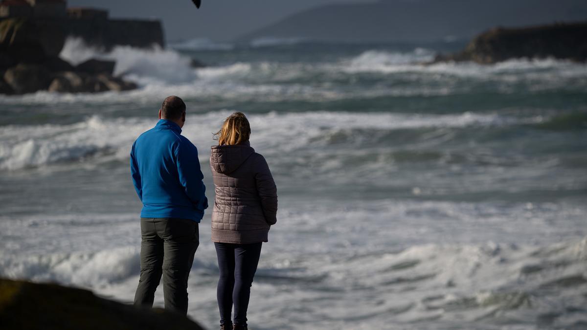 Dos personas observan el mar con olas por el temporal, en la playa de A Lanzada, a 5 de noviembre de 2023, en O Grove, Pontevedra, Galicia (España).