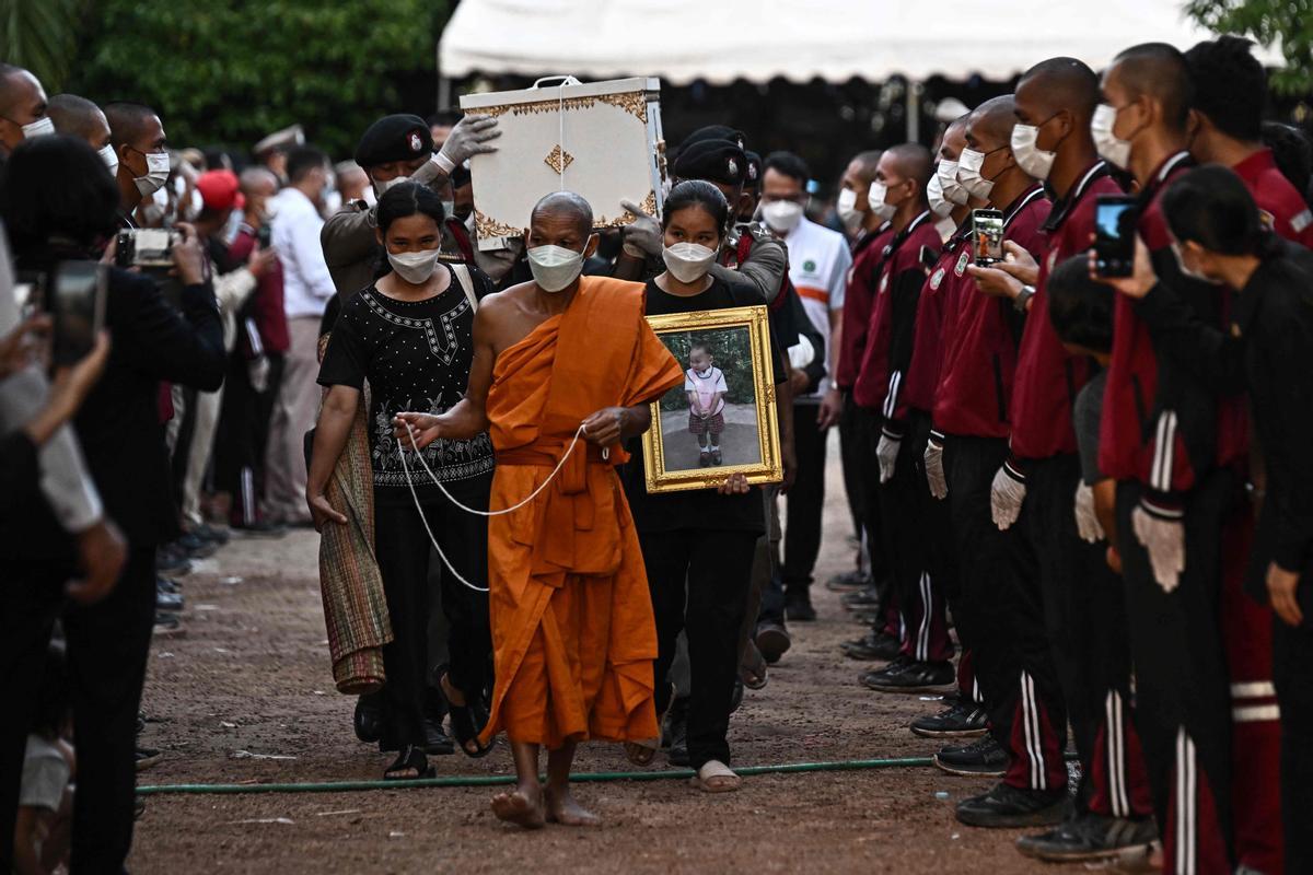 La gente observa cómo las piras funerarias incineran a 19 víctimas del tiroteo en la guardería de Uthai Suwan en el templo Wat Rat Samakee en Uthai Sawan. Un exoficial de policía disparó y mató a 37 personas, al menos 24 de ellos niños, después de irrumpir en una guardería infantil en el noreste de Tailandia.