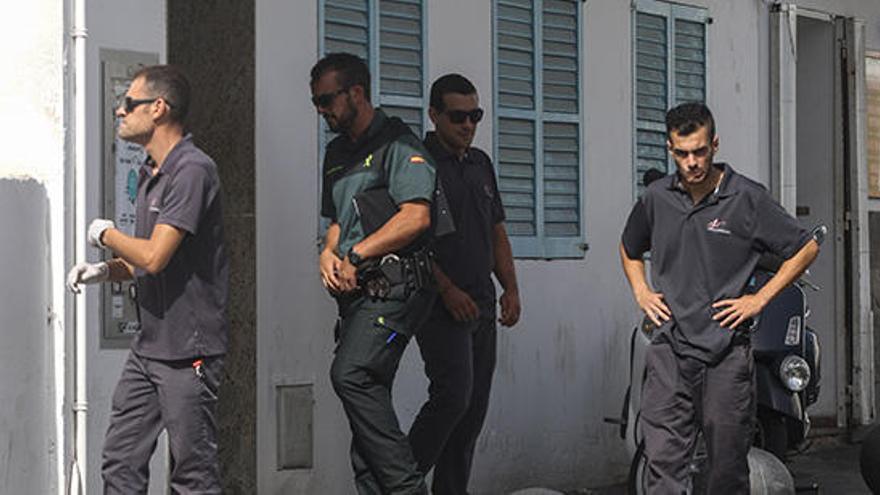 Los agentes de la Guardia Civil y los trabajadores de los servicios funerarios, horas después del suceso, frente al edificio en el que tuvo lugar la pelea.