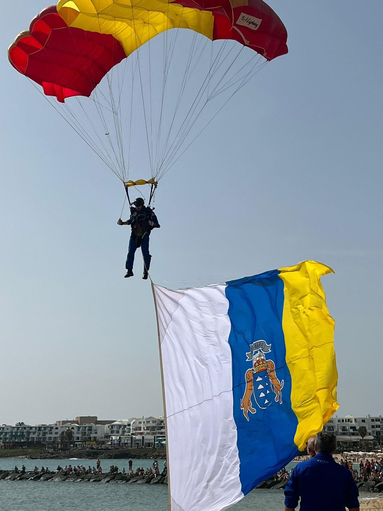 El paracaidista del PAPEA a punto de aterrizar en la playa de Las Cucharas con la bandera canaria