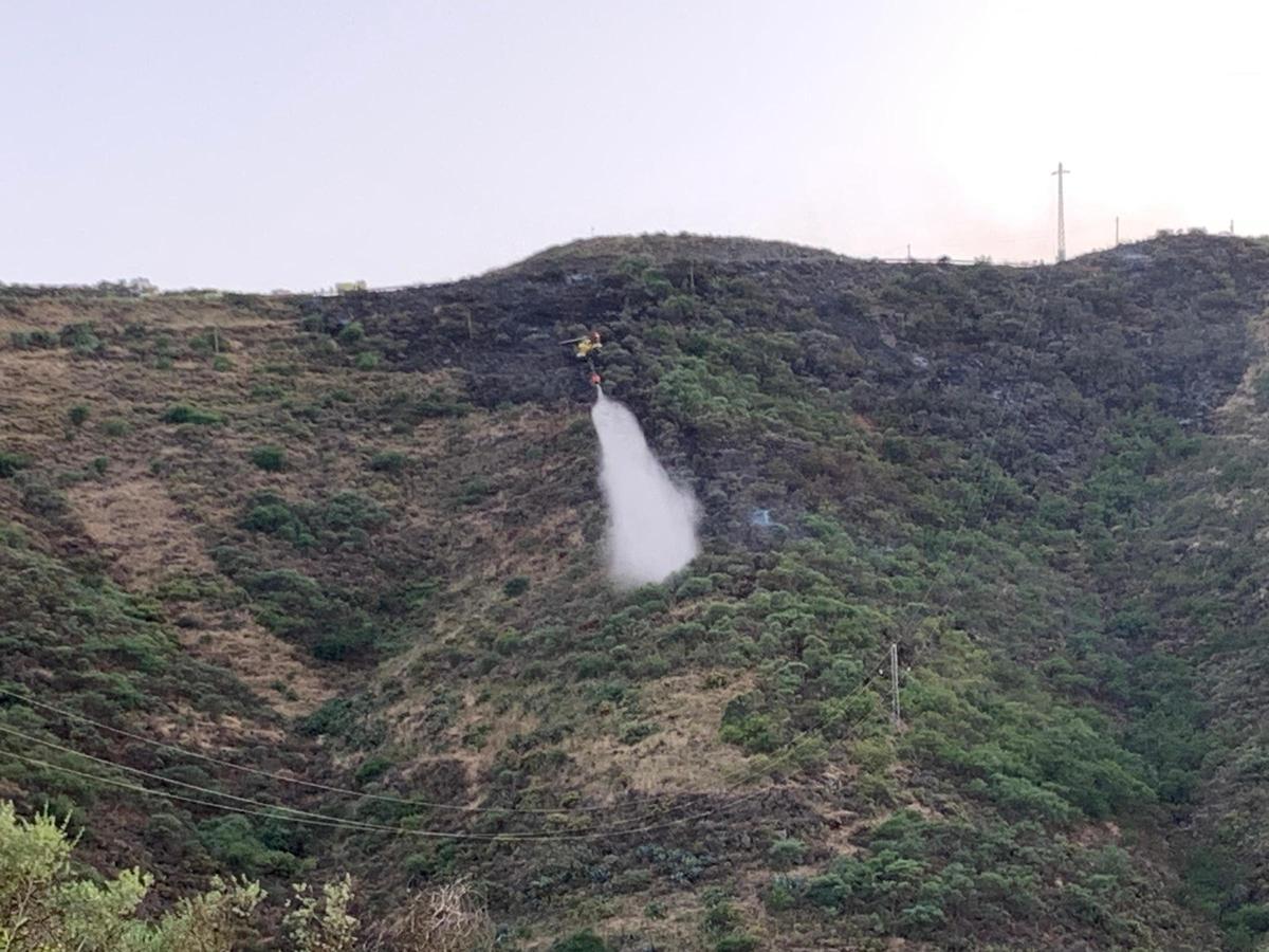 Un helicóptero descarga agua en la zona del incendio, en las medianías de Telde.