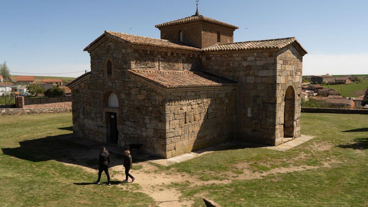 Unos visitantes en el exterior de la iglesia visigoda de San Pedro de la Nave en El Campillo. | J. L. FERNÁNDEZ (ARCHIVO)
