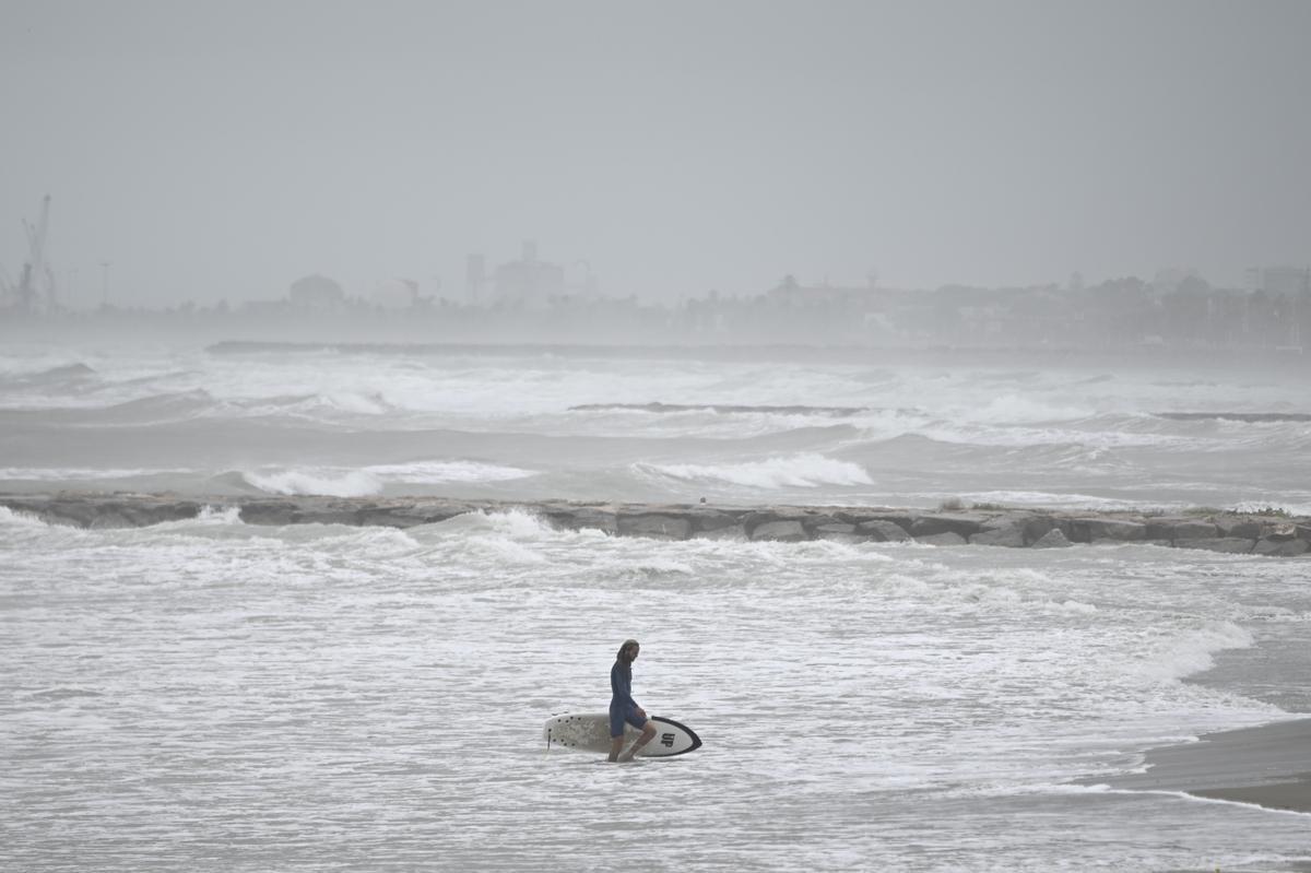 Un surfisca sale del agua en la playa del Heliópolis de Benicàssim este domingo