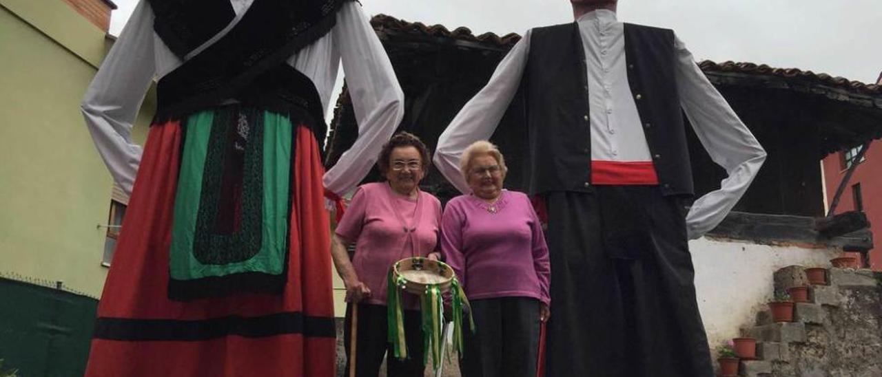 Isabel y Maruja Díaz con los gigantes del desfile de las fiestas de San Antoniu, ayer, en el barrio de La Concepción de Cangas de Onís.