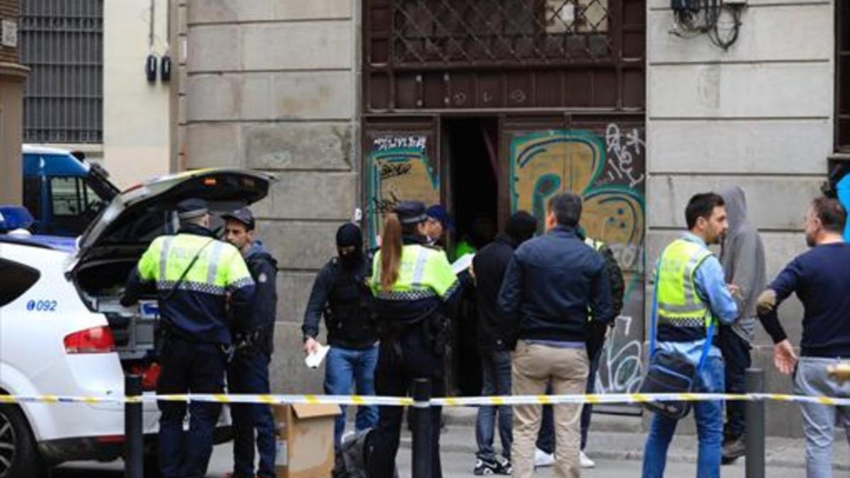 Un momento de la actuación de guardias urbanos y mossos en el narcopiso ubicado en los bajos de un edificio de la plaza de los Traginers, ayer,