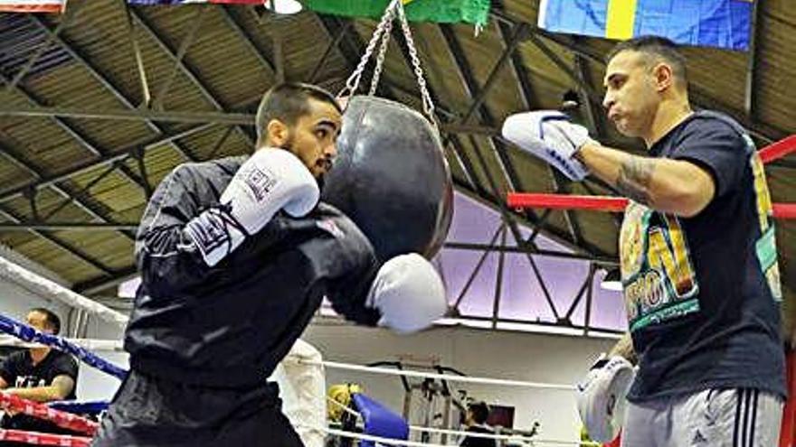 Nano Santana -izquierda- con su entrenador Carlos Formento -derecha- haciendo guantes sobre el ring.