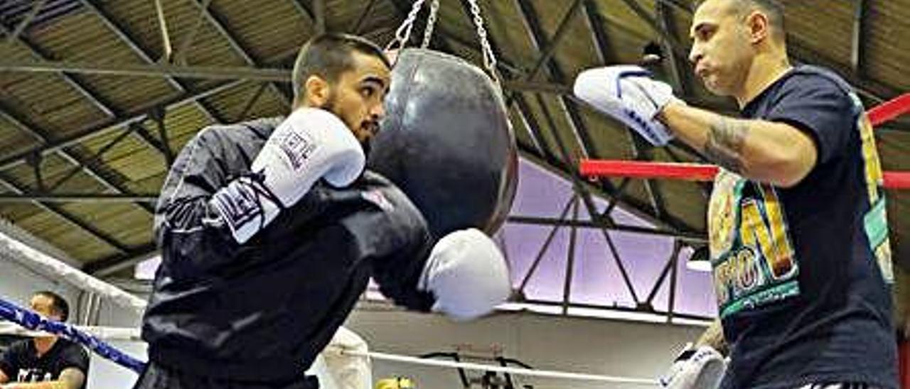 Nano Santana -izquierda- con su entrenador Carlos Formento -derecha- haciendo guantes sobre el ring.