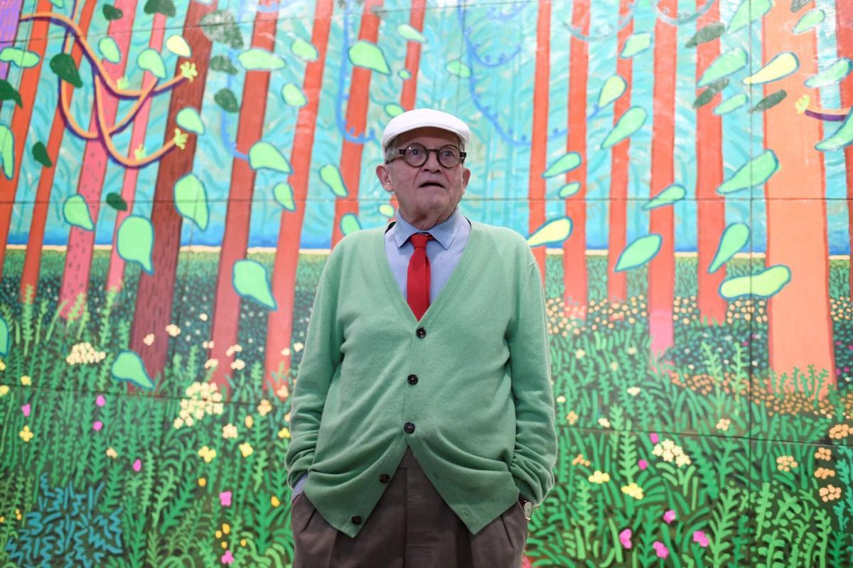 Hockney en el Pompidou, con uno de sus grandes y coloristas paisajes de fondo.