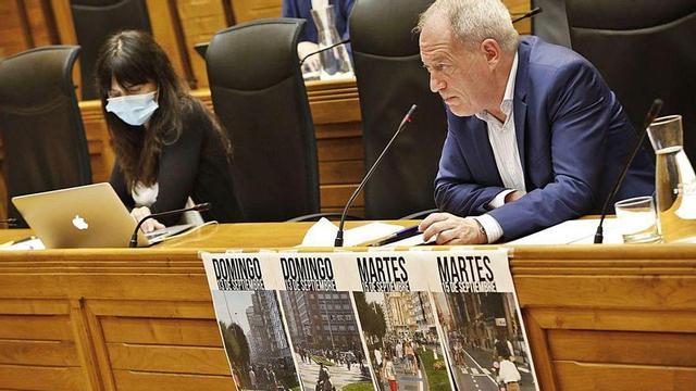 Aurelio Martín, durante una intervención, con carteles con fotos de la zona peatonal del Muro.