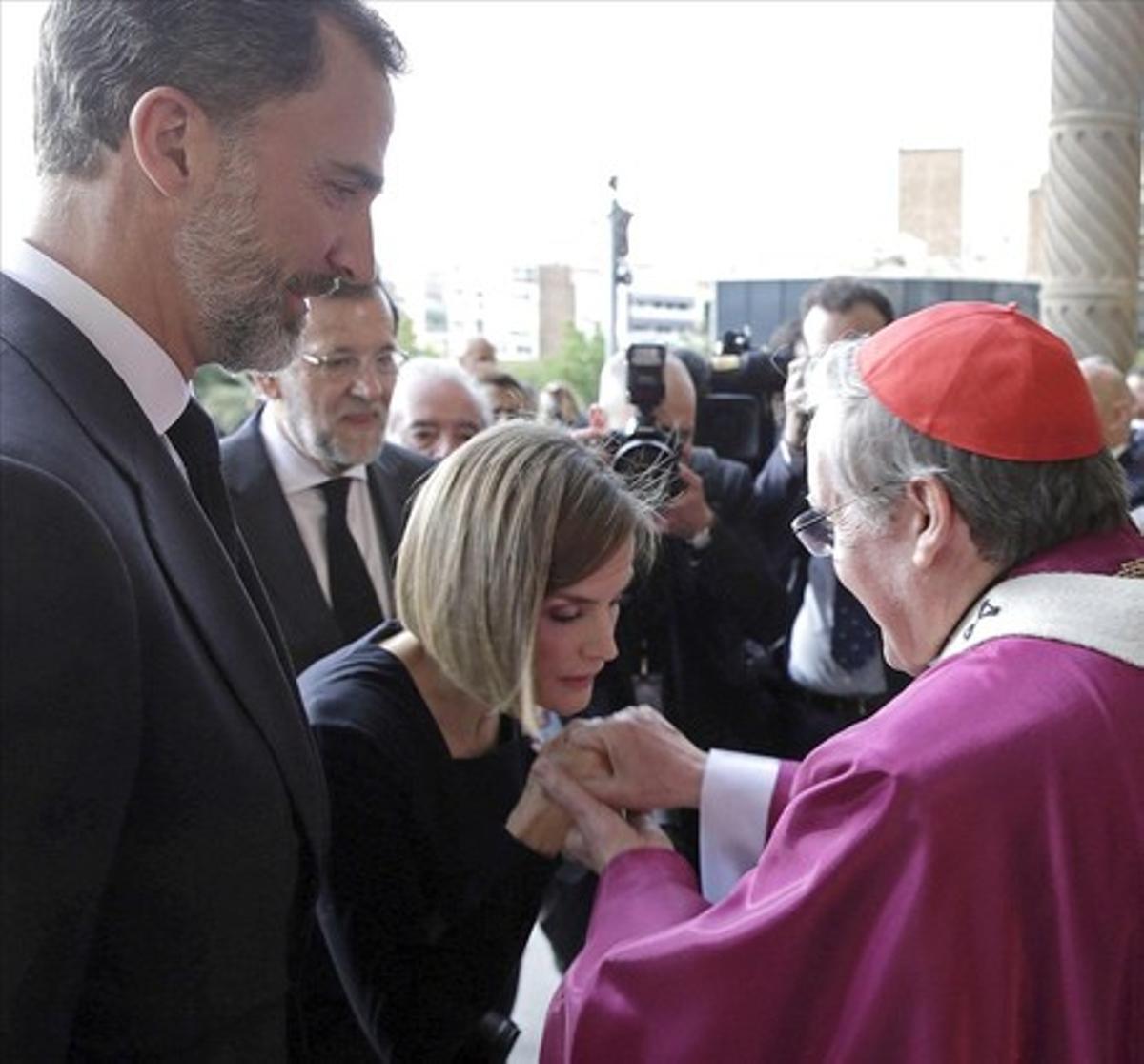 Los Reyes de España saludan al arzobispo-cardenal de Barcelona, Lluís Martínez Sistach (d), a su llegada a la basílica de la Sagrada Familia de Barcelona para asistir al funeral institucional en homenaje a las 150 víctimas del avión de Germanwings