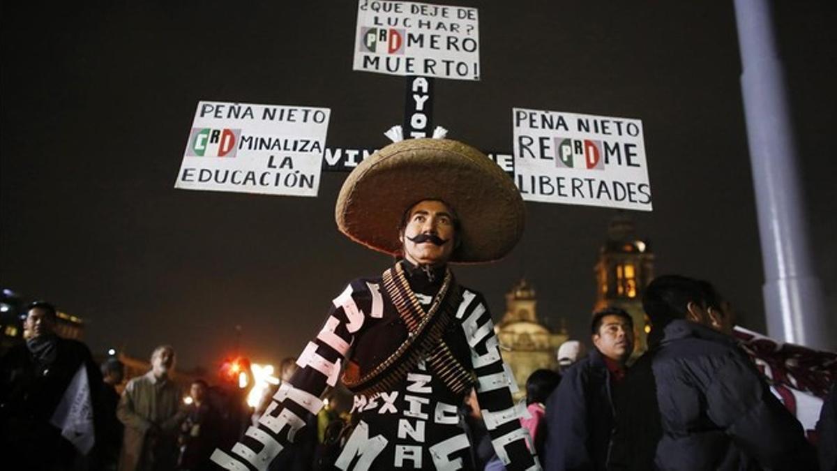 Un manifestante vestido de revolucionario con carteles críticos con Peña Nieto, durante la protesta en la capital mexicana.