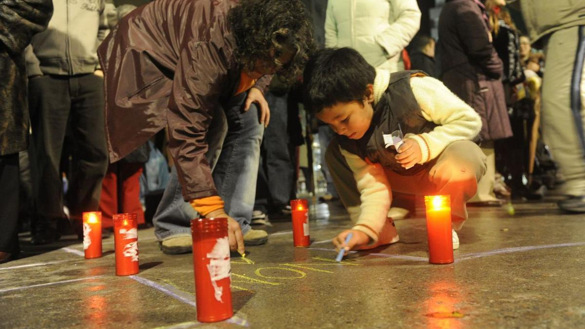 Una mujer y un niño escriben
“Non” a la violencia de género en 
una manifestación en Galicia.   | // F.M.