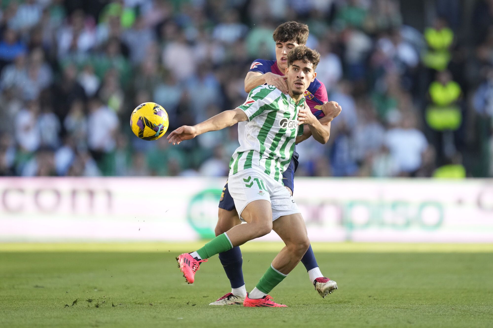 Betis' Abde Ezzalzouli, front, challenges for the ball with Barcelona's Pau Cubarsi during a Spanish La Liga soccer match between Betis and Barcelona at the Benito Villamarin stadium in Seville, Spain, Saturday, Dec. 7, 2024. (AP Photo/Jose Breton). EDITORIAL USE ONLY/ONLY ITALY AND SPAIN