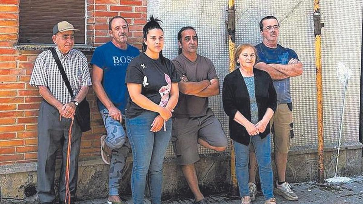 Vecinos de Pumarabule, ayer, ante una de las casas agrietadas.