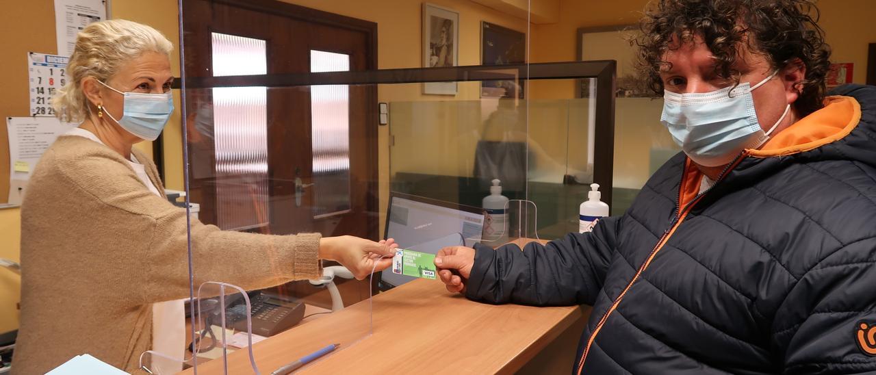 Leticia Martínez, técnica municipal, ayer, entregando la tarjeta a Toni Fernández, ganadero de Remoria (Pruvia).