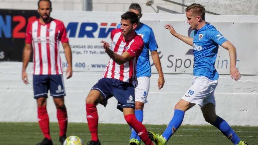 Un jugador local se adelanta a un rival en el partido disputado ayer en Cangas. // Santos Álvarez