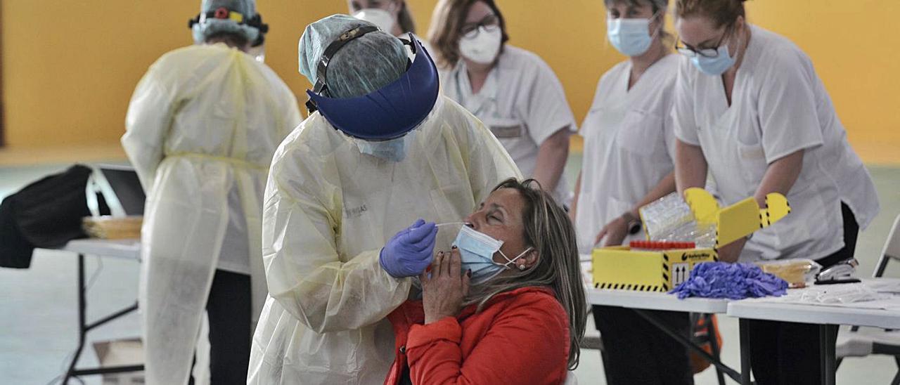 Una mujer se somete a una PCR en el pabellón municipal de San Antoniño de Barro.  // RAFA VÁZQUEZ