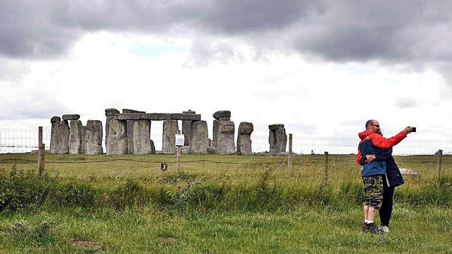 Dos turistas se fotografían en el monumento de Stonehenge.