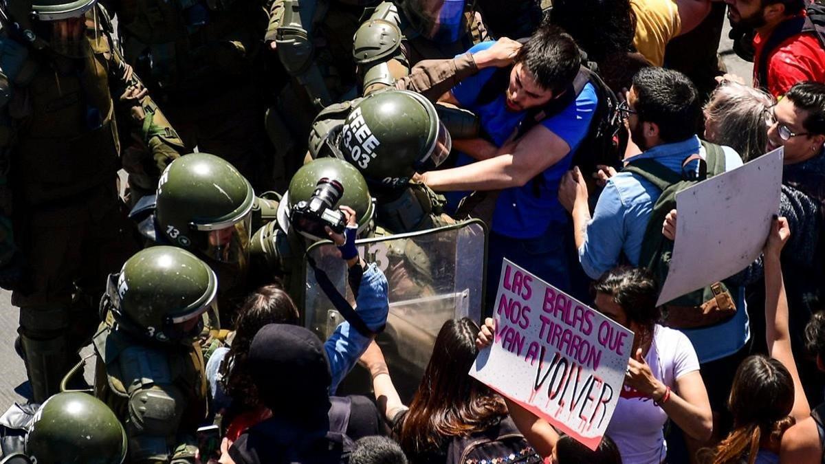 Manifestantes forcejean con la policía en Santiago de Chile.