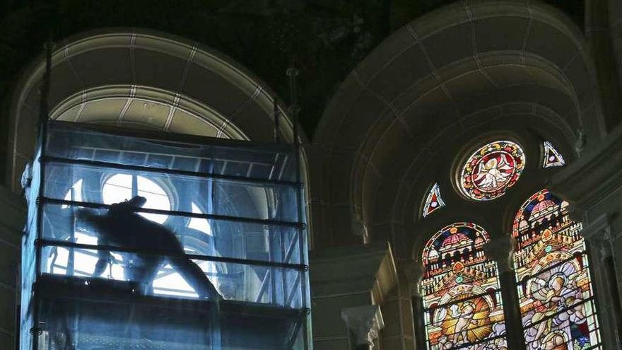 Un trabajador en la ventana de San Juan el Real sobre la que se repondrá la vidriera restaurada.