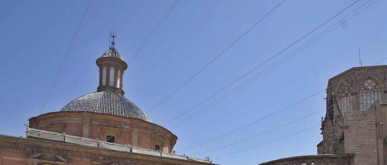 Dos turistas visitan una plaza de la Virgen de València semidesierta, el pasado verano. | F. BUSTAMANTE