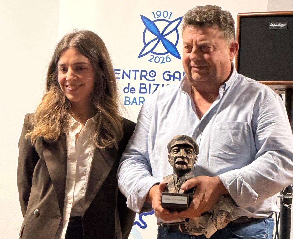 Maren, filla de Kepa, entregando o busto a Urbano Alba, presidente do centro galego.