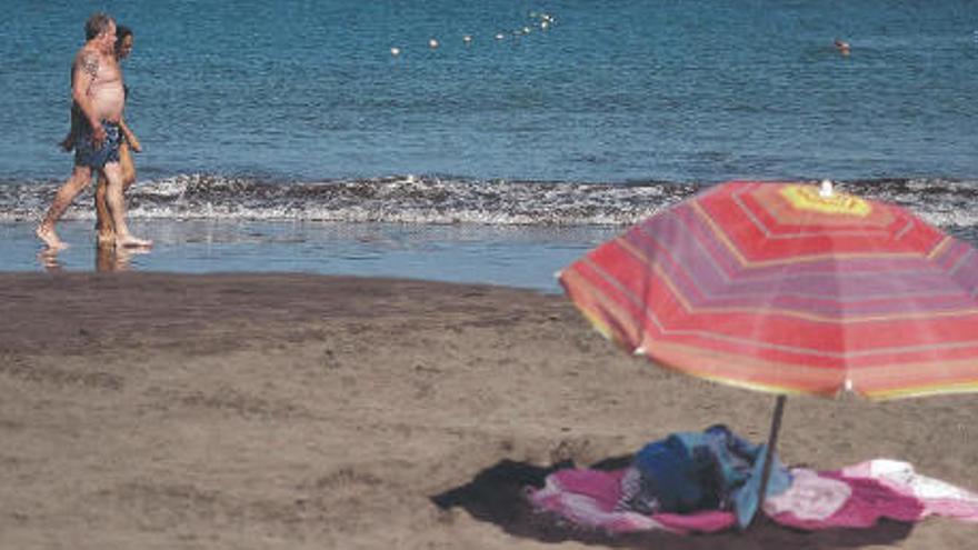 Dos personas pasean por una solitaria playa del sur de Tenerife.