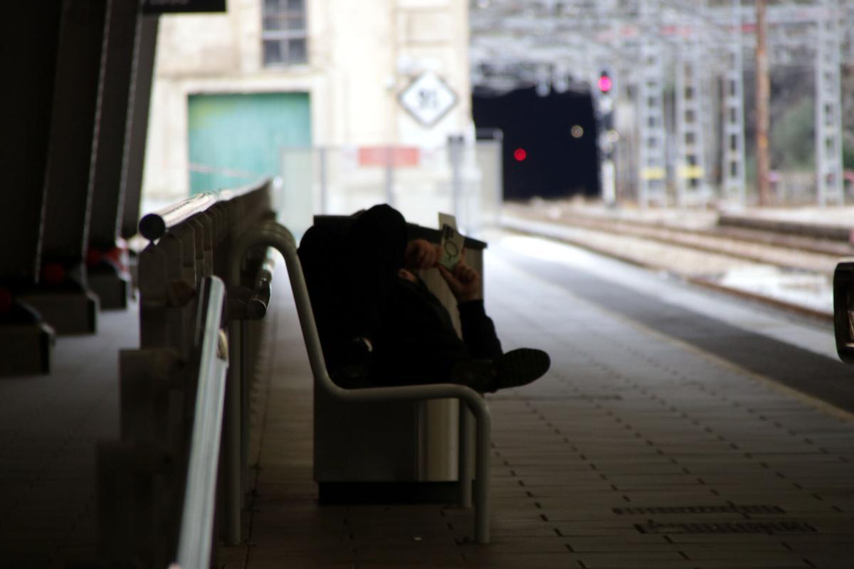 Una persona en un banco de la estación de Portbou