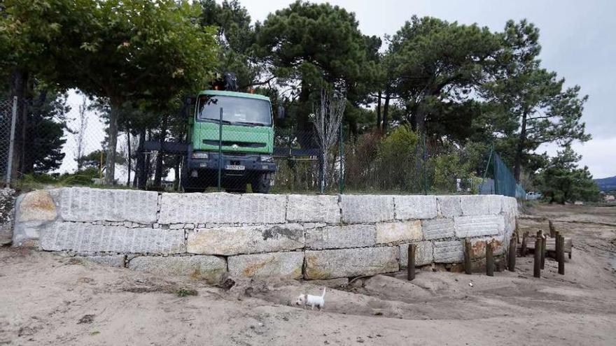Un camión preparado para iniciar los trabajos, junto a los restos de la pasarela en A Ladeira.