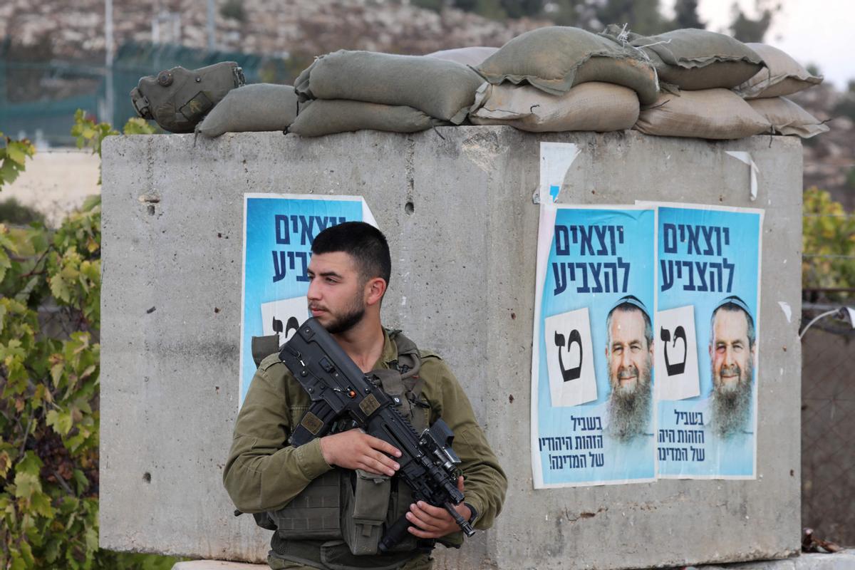 Un soldado israelí está desplegado en una posición cerca de Kiryat Arba en la Cisjordania ocupada en las afueras de Hebrón,cuando los israelíes comenzaron a votar en su quinta elección en menos de cuatro años, con el veterano líder Benjamin Netanyahu haciendo campaña para un regreso. junto a aliados de extrema derecha.
