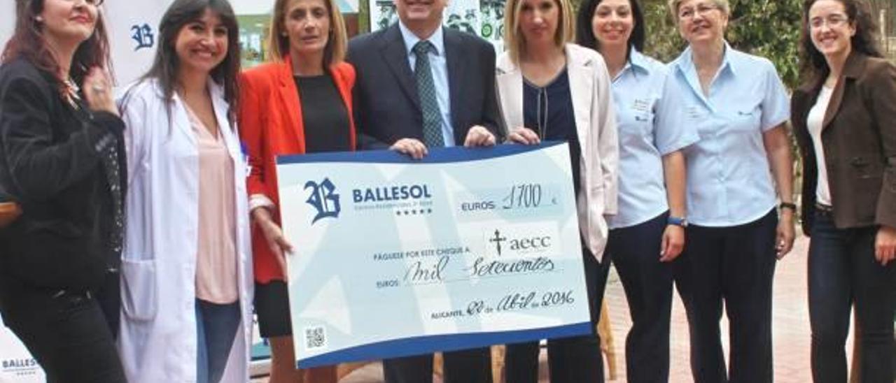 El equipo de Ballesol con el talón entregado a la AECC.