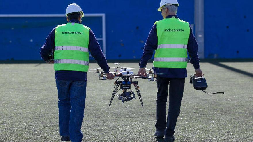 Operarios de Endesa con uno de los drones que usa para la inspección de torretas de alta tensión.