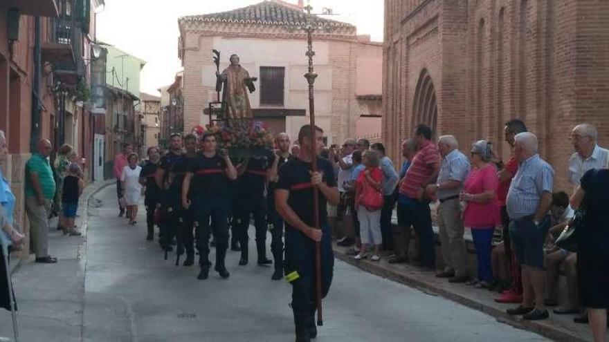 Bomberos de Toro portan a hombros la imagen de su patrón durante la procesión.