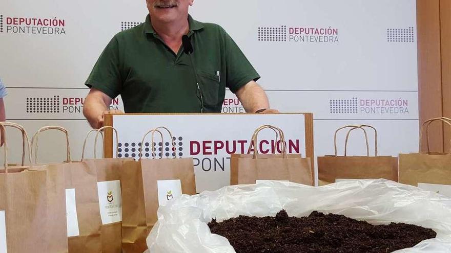 César Mosquera ante varias bolsas de compost. // Gustavo Santos