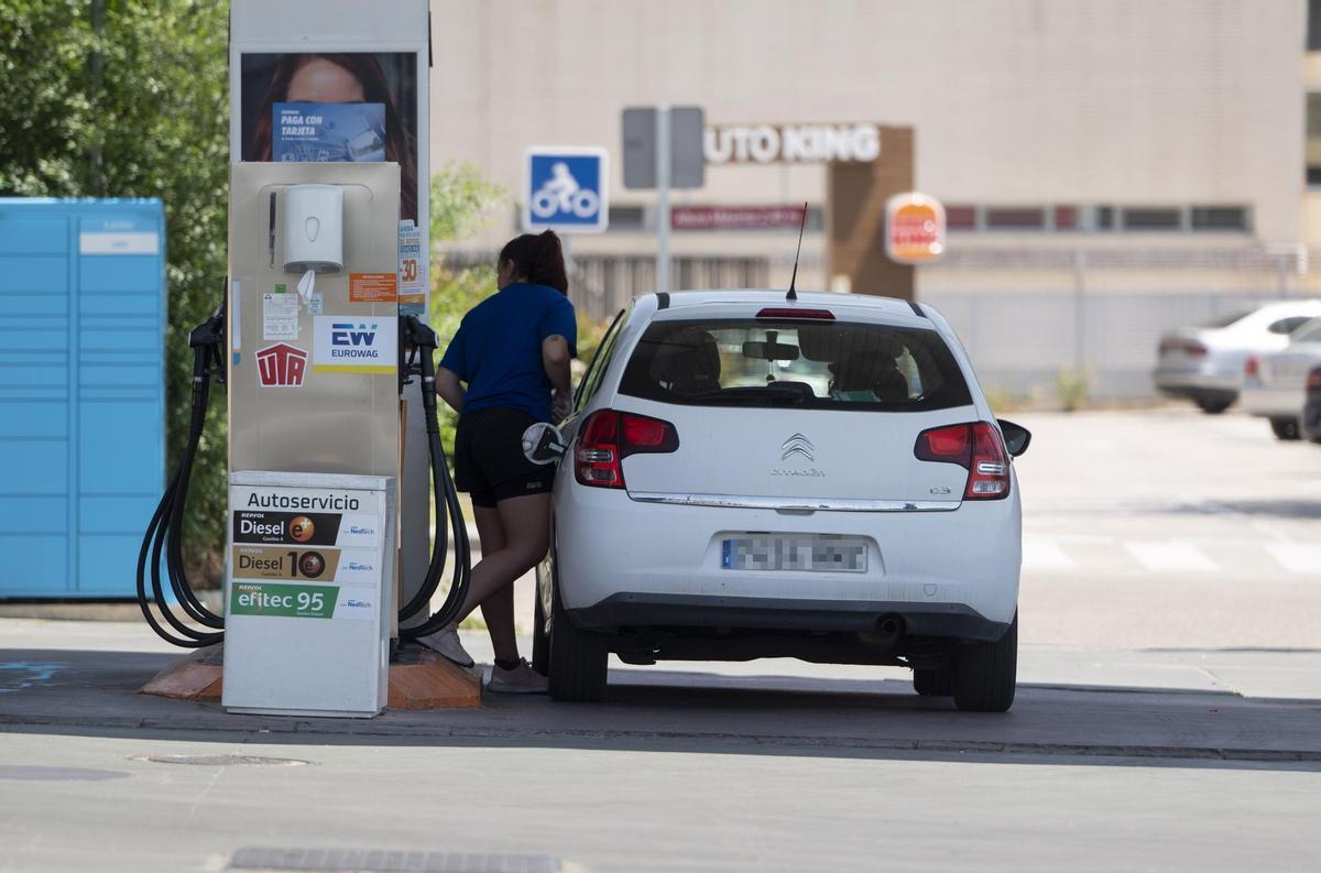 Archivo - Una mujer reposta en una gasolinera