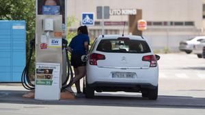 Archivo - Una mujer reposta en una gasolinera