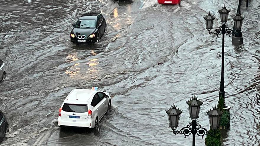 Una espectacular tormenta con granizo inunda varias calles de Oviedo y cala a los peatones