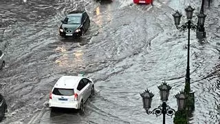 Una espectacular tormenta con granizo  inunda varias calles de Oviedo y cala a los peatones