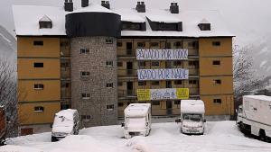 El antiguo cuartel de la Guardia Civil, junto a la carretera C-28, en Baqueira, cubierto de pancartas, este viernes.