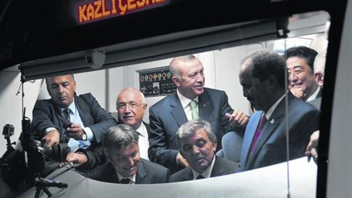 Erdogan (de pie, en el centro) escucha con otros dirigentes las explicaciones de un conductor del metro, ayer.