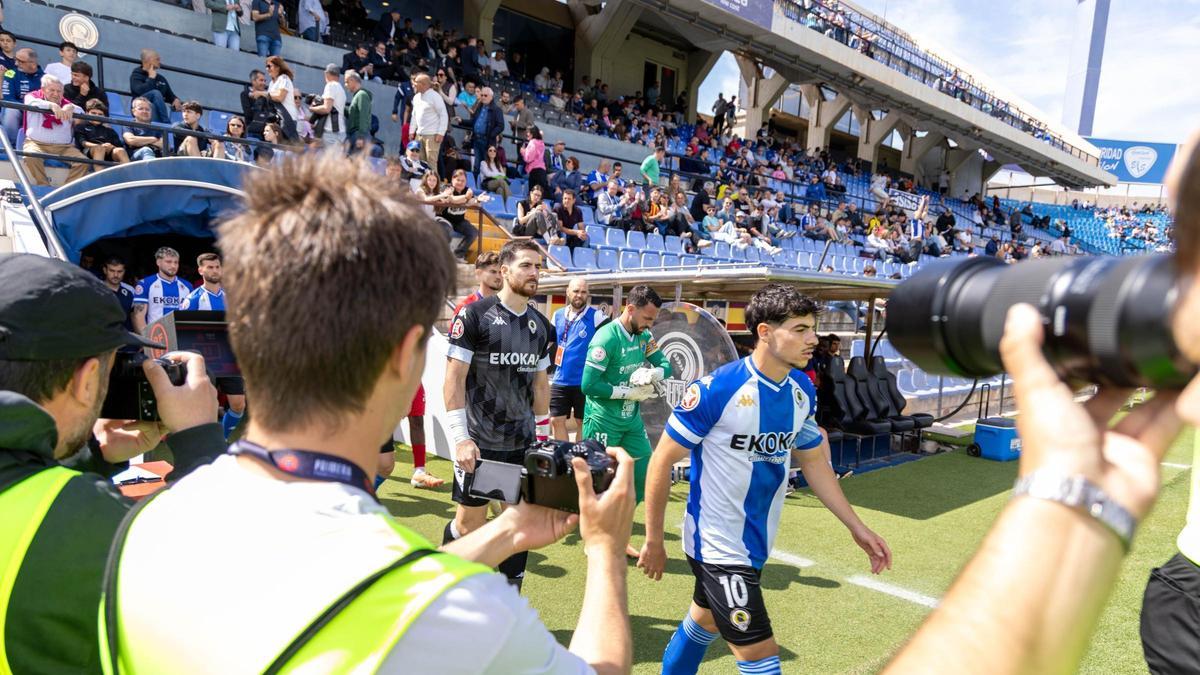 Los jugadores del Hércules salen al campo con sus capitanes al frente, Nico Espinosa y Carlos Abad.
