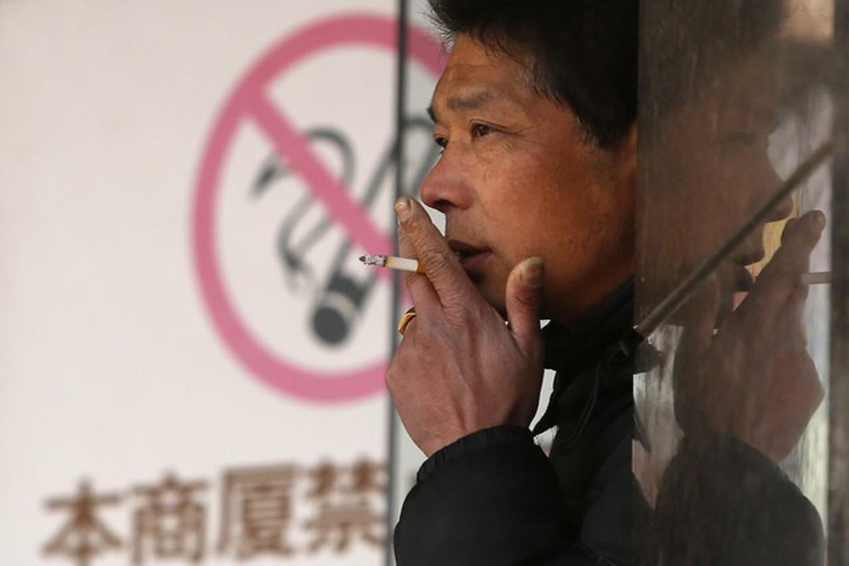 Un home fuma al costat d’un cartell que prohibeix fumar, en un centre comercial de Xangai, el 10 de gener. Un home fuma al costat d’un cartell que prohibeix fumar, en un centre comercial de Xangai, el 10 de gener.