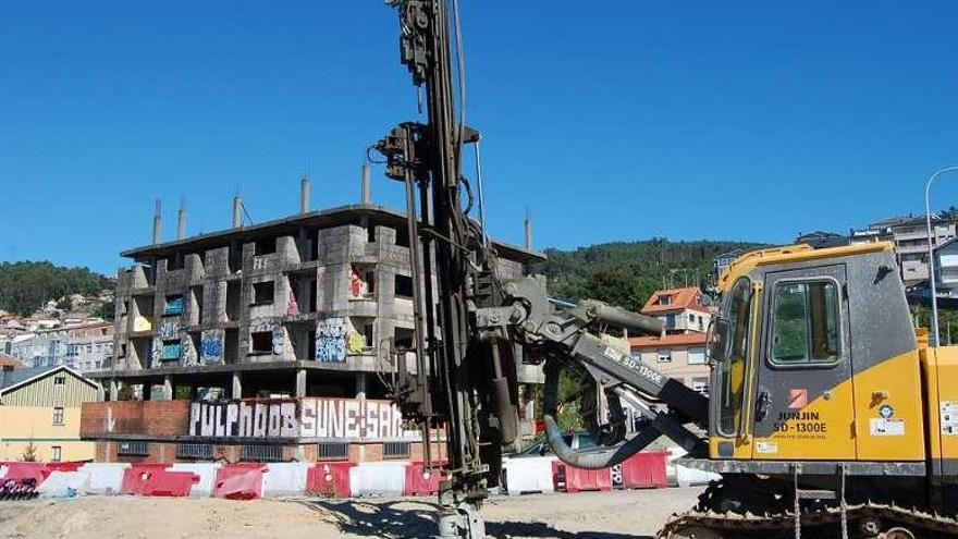 Maquinaria de las obras de la AP-9 junto al polémico edificio. // FdV