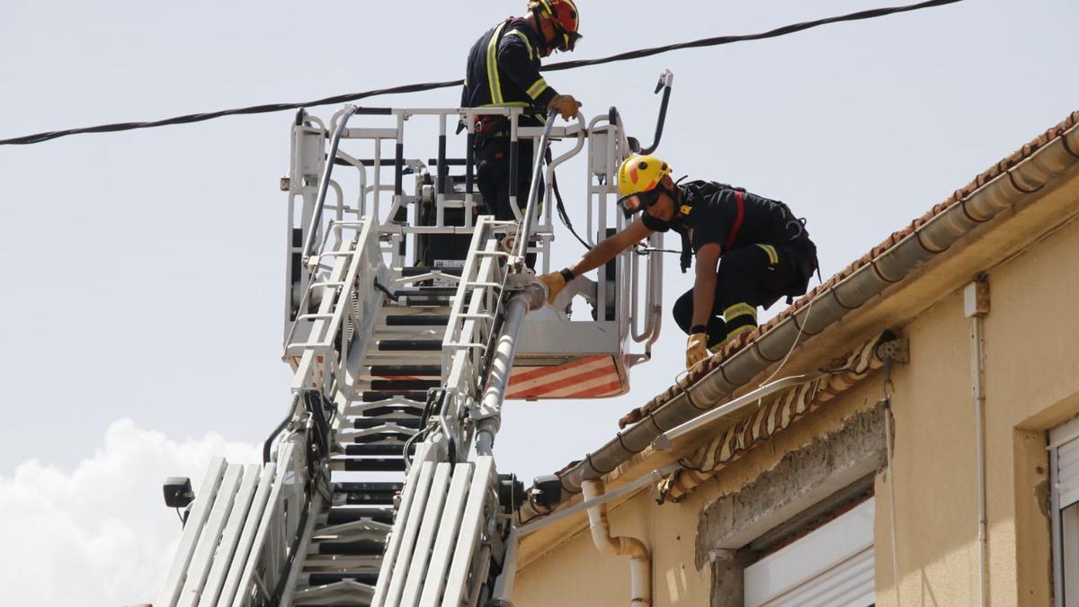 Los bomberos revisando los tejados en Beneixama.