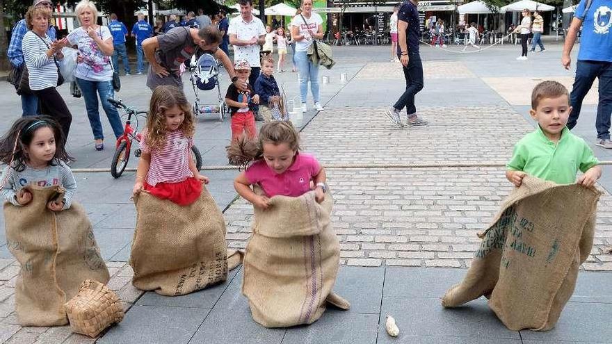 Participantes en el encuentro de juegos tradicionales, durante una carrera de sacos.