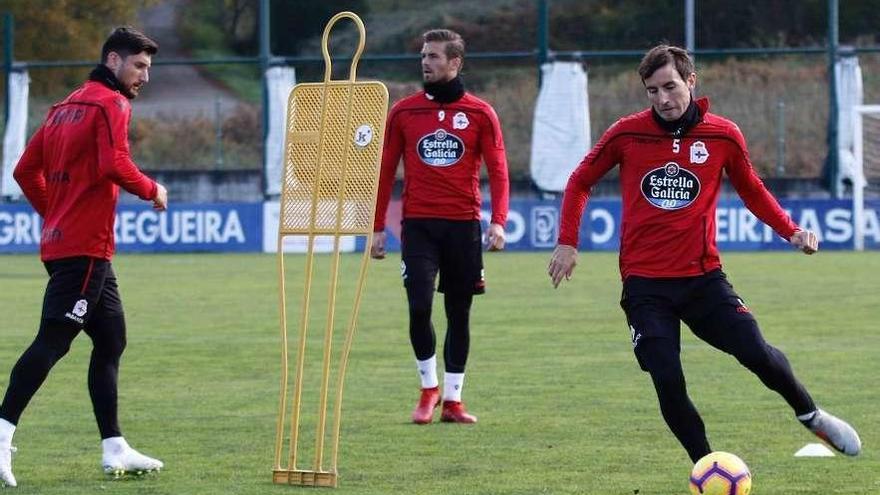 Pedro Mosquera, a la derecha, golpea el balón junto a Borja Valle y Christian Santos ayer en Abegondo.