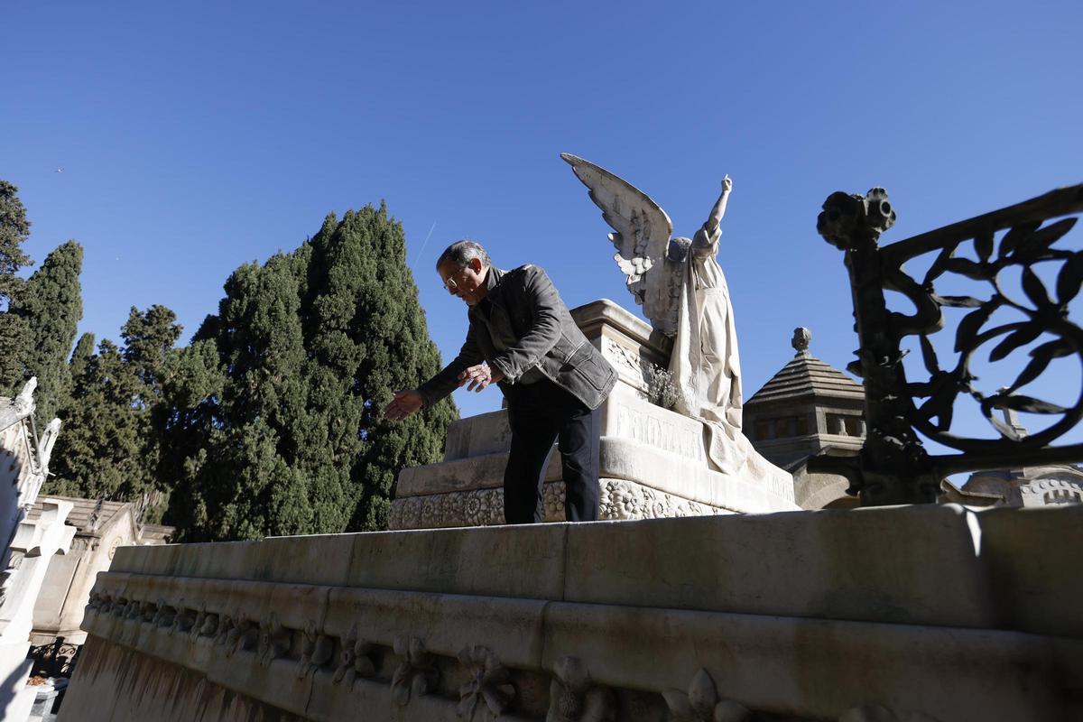 Albert Sáenz señala el tramo de valla saqueado en el panteón Coromina, en el cementerio de Montjuïc, en Barcelona.