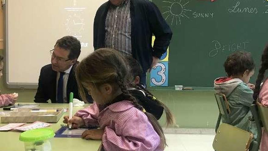 Alonso, sentado, y García Saiz, durante la visita al colegio.